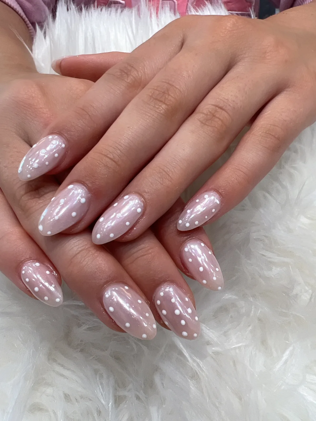 Pearly pink almond nails with small white dot accents in Gilbert, AZ