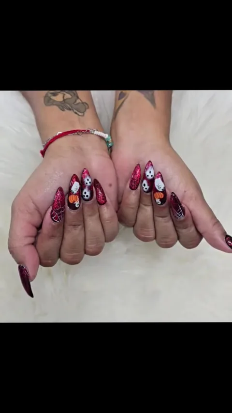 Red glitter Halloween nails with ghosts, pumpkins and spiderwebs at Apple Nailed It Spa in Gilbert