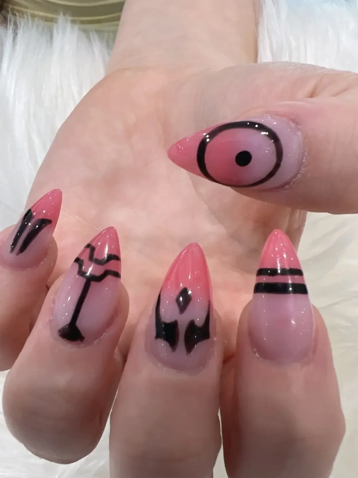 Pink pointed nails with black graphic line designs