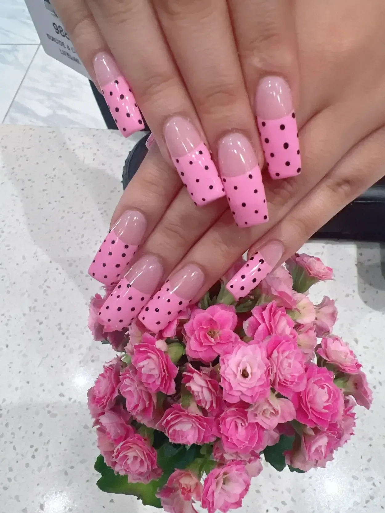 Long square nails with pink French tips and black dots