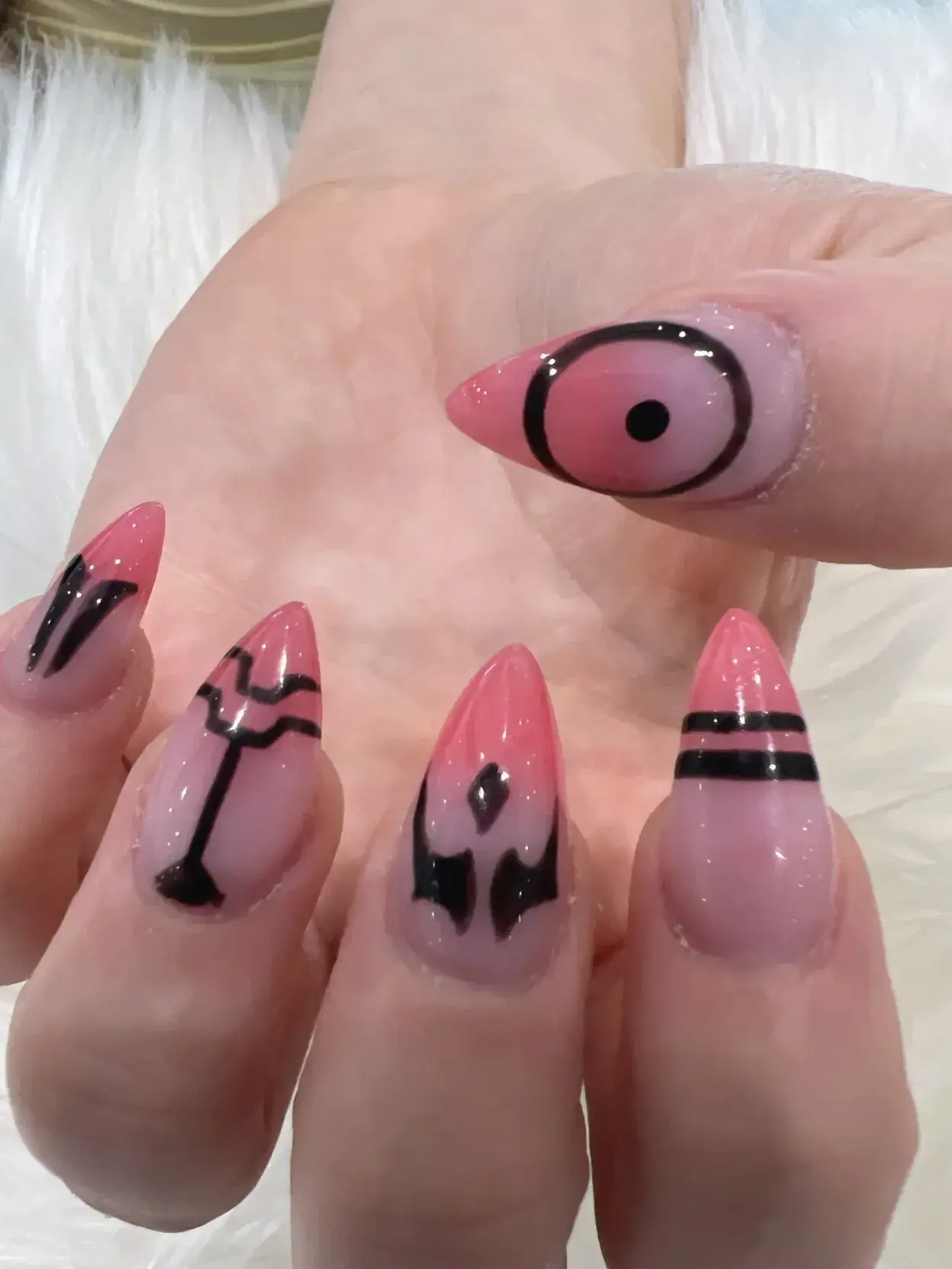 Pink pointed nails with black graphic line designs