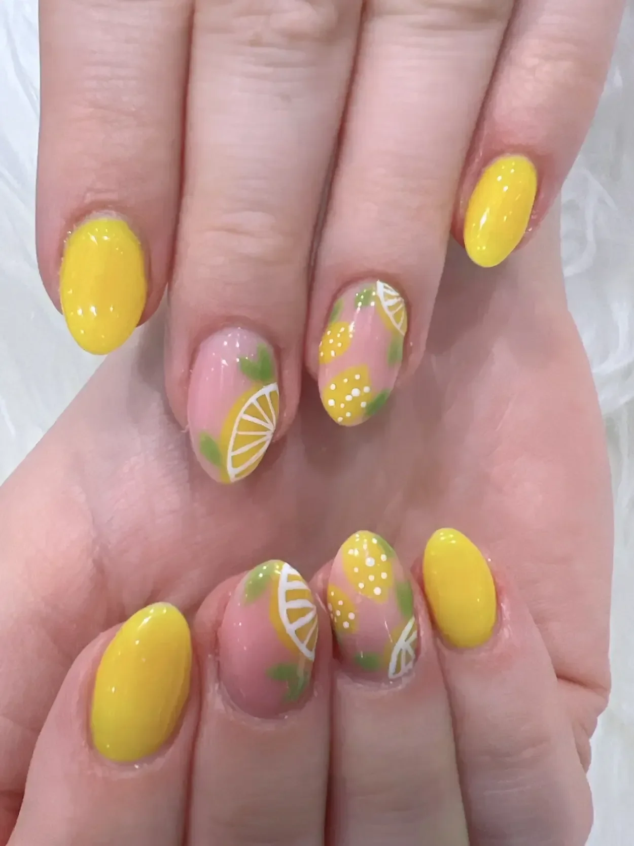 Yellow almond-shaped nails with lemon designs