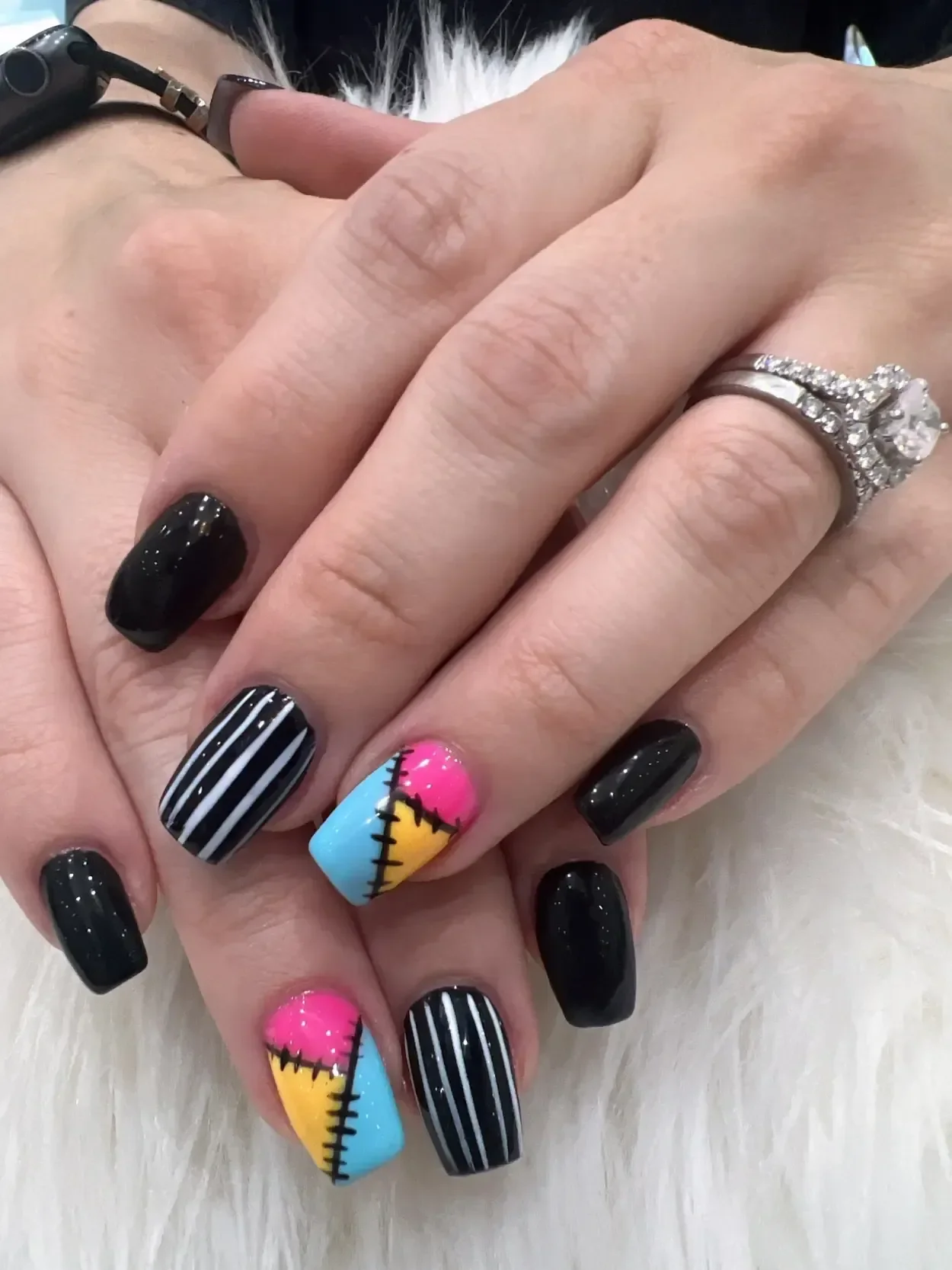Black square nails with striped and colorful patchwork accents