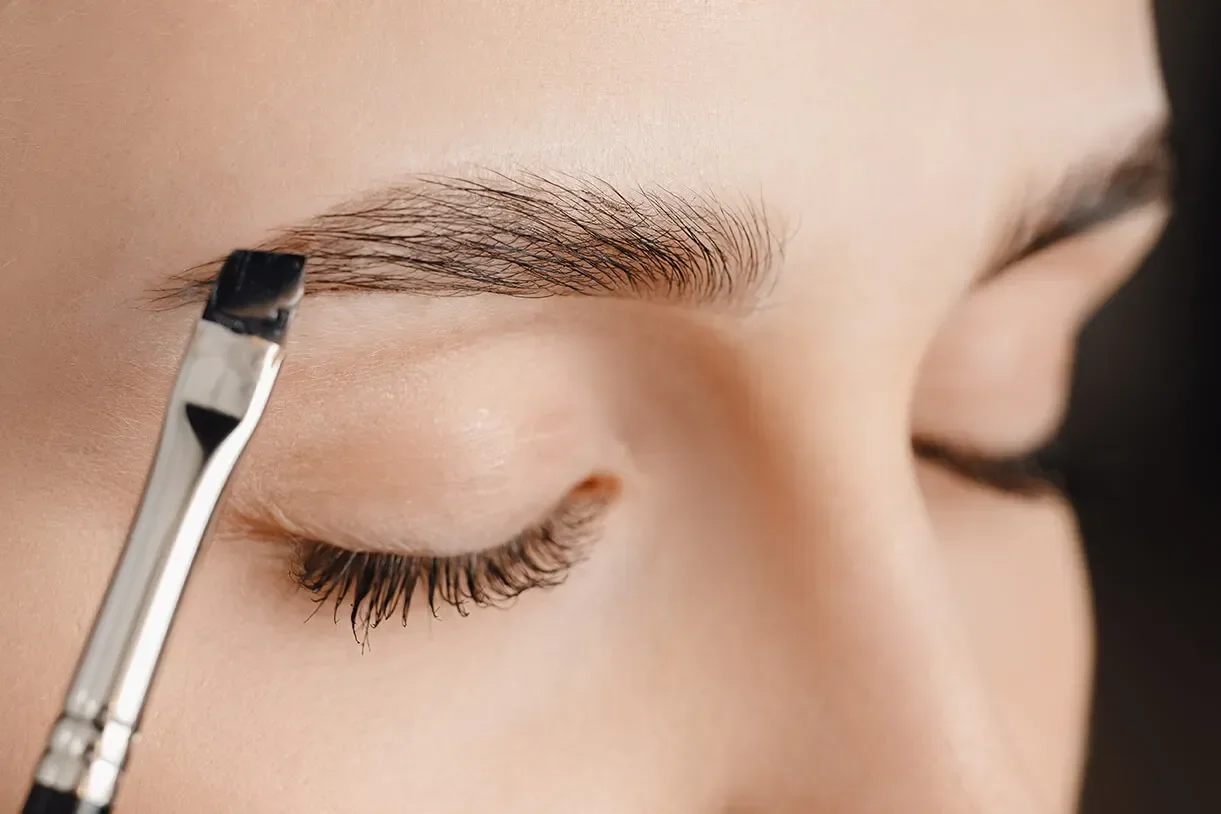 Eyebrow tinting being applied by a salon technician